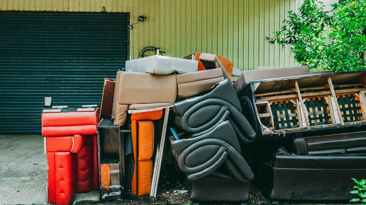 Pile of old furniture stacked in front of a garage
