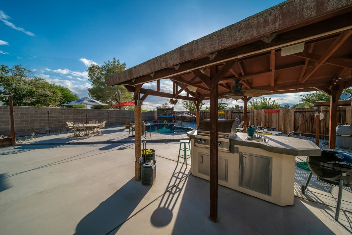 Covered patio with a grill and a dining table