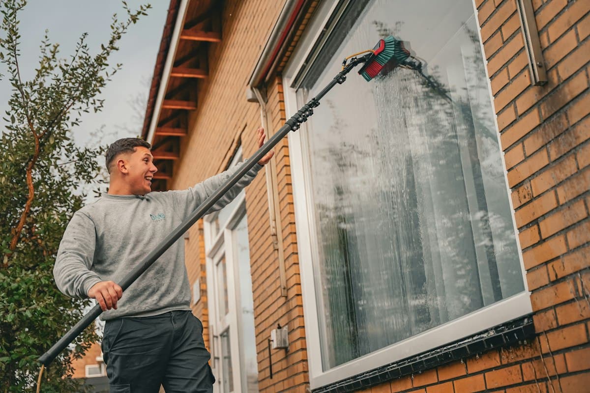 Window cleaner using a water-fed pole on a house