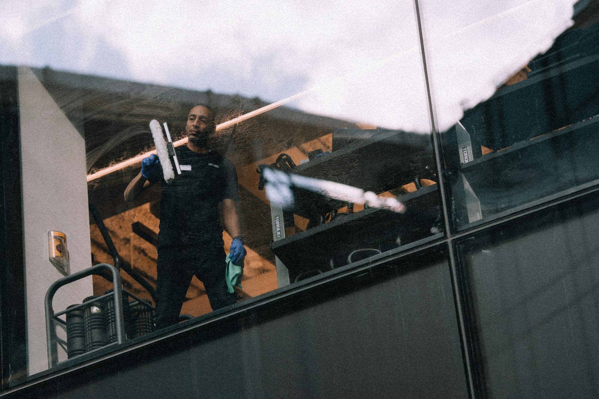 Window cleaner squeegeeing the glass facade of a building